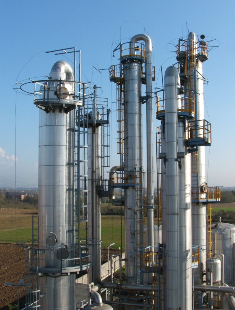 Three industrial distillation columns with connecting pipework and access platforms.